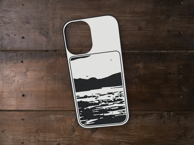 Printed phone case with a mountain lake in black and white on the back, lying on a wooden table