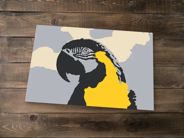 Flat colour print of a parrot in five filament colours on a wooden table
